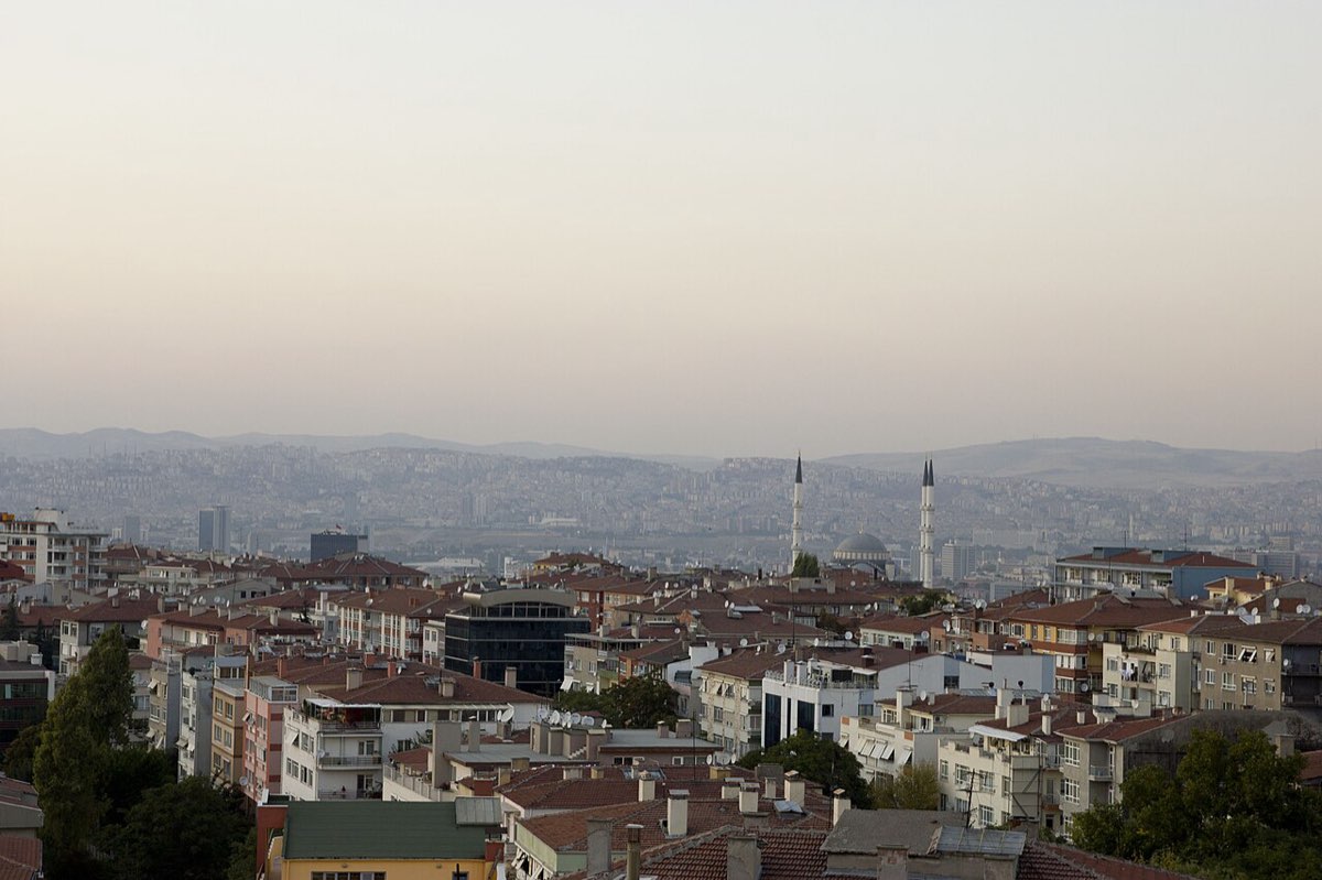 Ankara at dusk, with housing in the foreground and the city stretching to the hills.